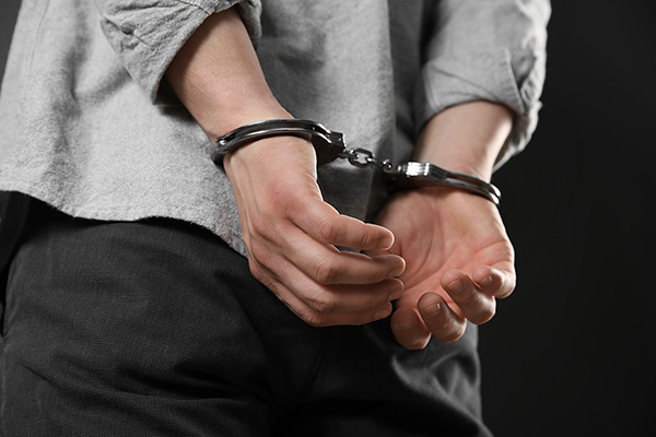 Man with hands behind his back in handcuffs