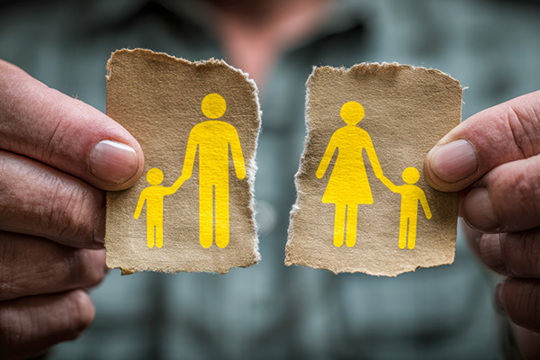 Person holding a torn piece of paper signifying a family breakup