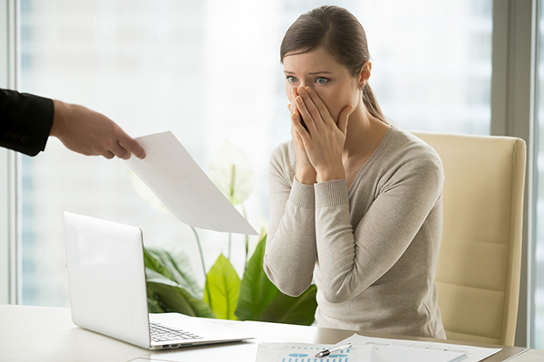 Woman at desk with shocked expression