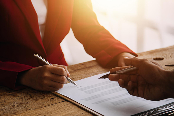 Woman at a desk signing an agreement