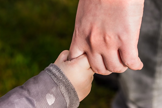 Child and adult holding hands