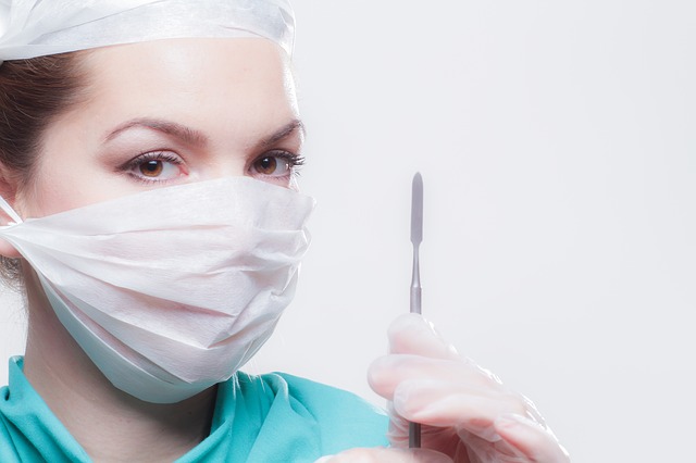 Surgeon in face mask holding a scalpel