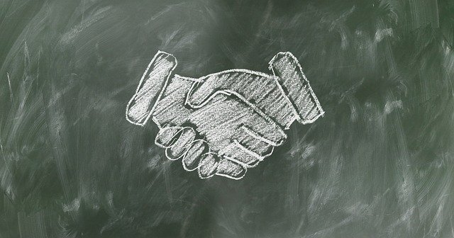 Shaking hands drawn in chalk on a blackboard